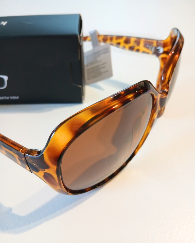 Tortoiseshell sunglasses with brown lenses on a white surface