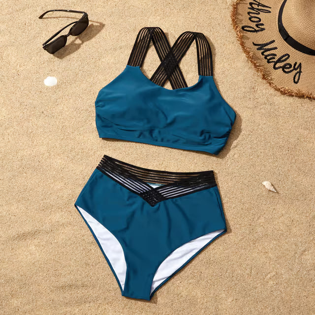 Blue bikini set on sand with sunglasses and a hat
