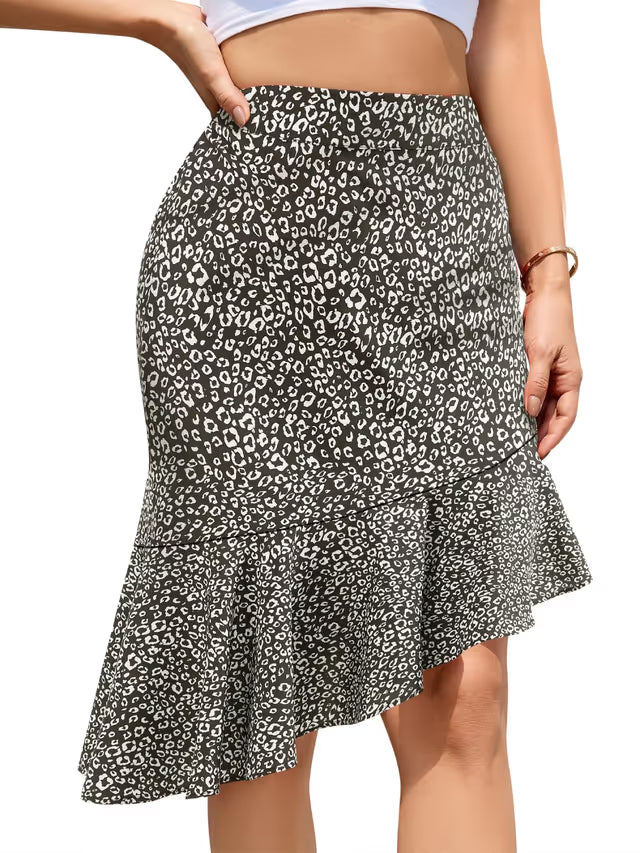 Black and white leopard print skirt worn by a person on a plain background