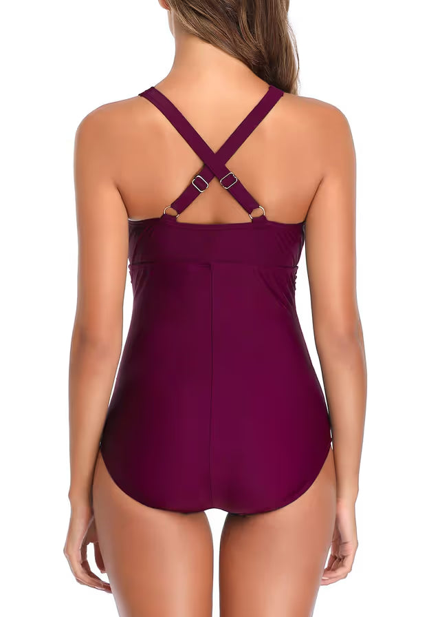 Purple swimsuit with criss-cross straps on a white background