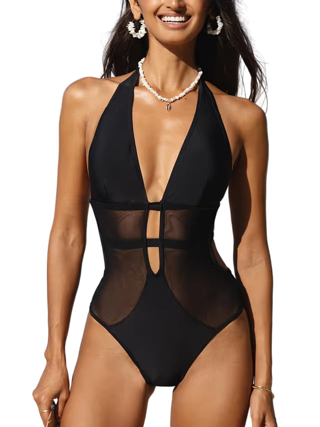 Woman wearing a black sheer swimsuit with a white background
