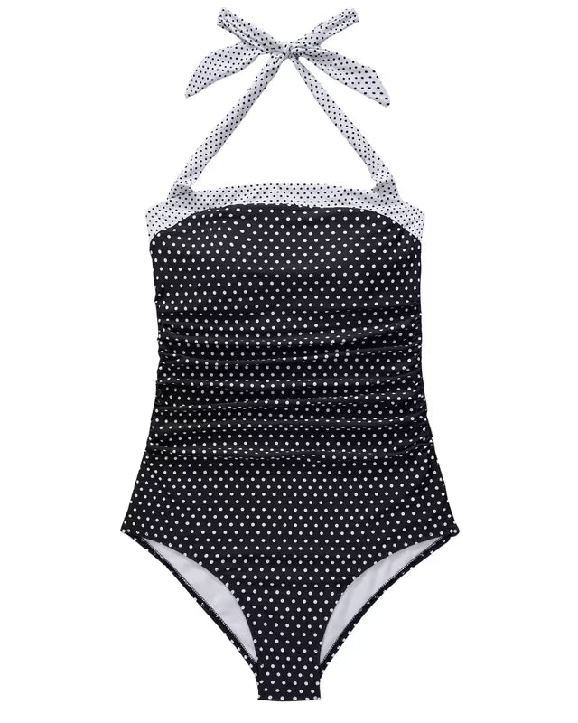 Black polka dot swimsuit with white straps on a white background