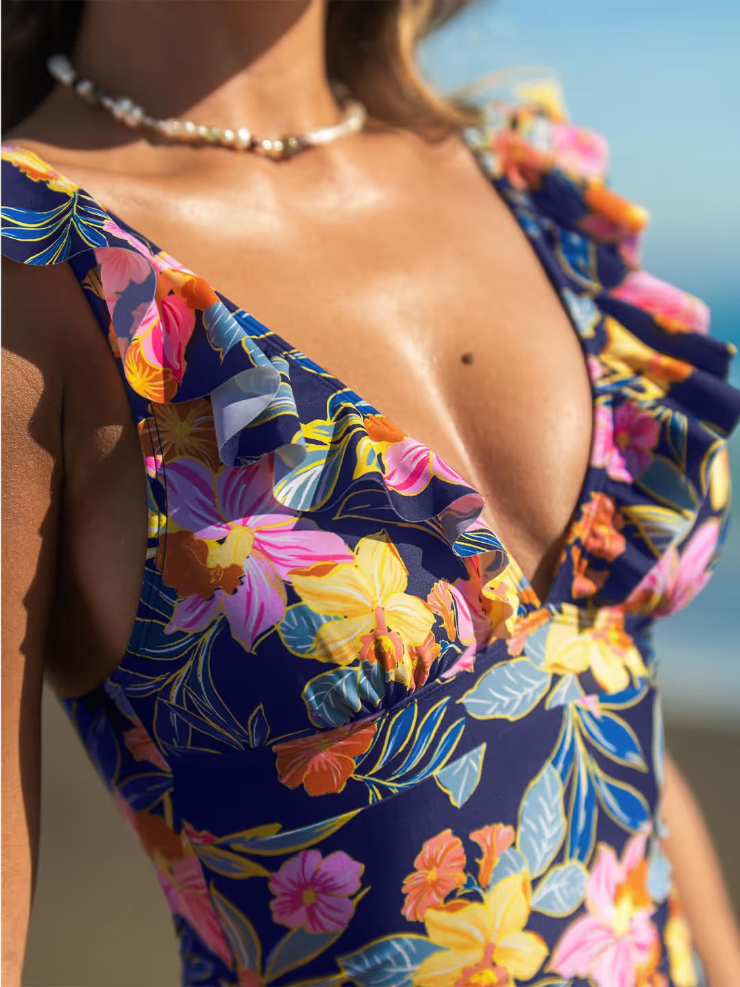 Woman wearing a colorful floral swimsuit with a blurred background