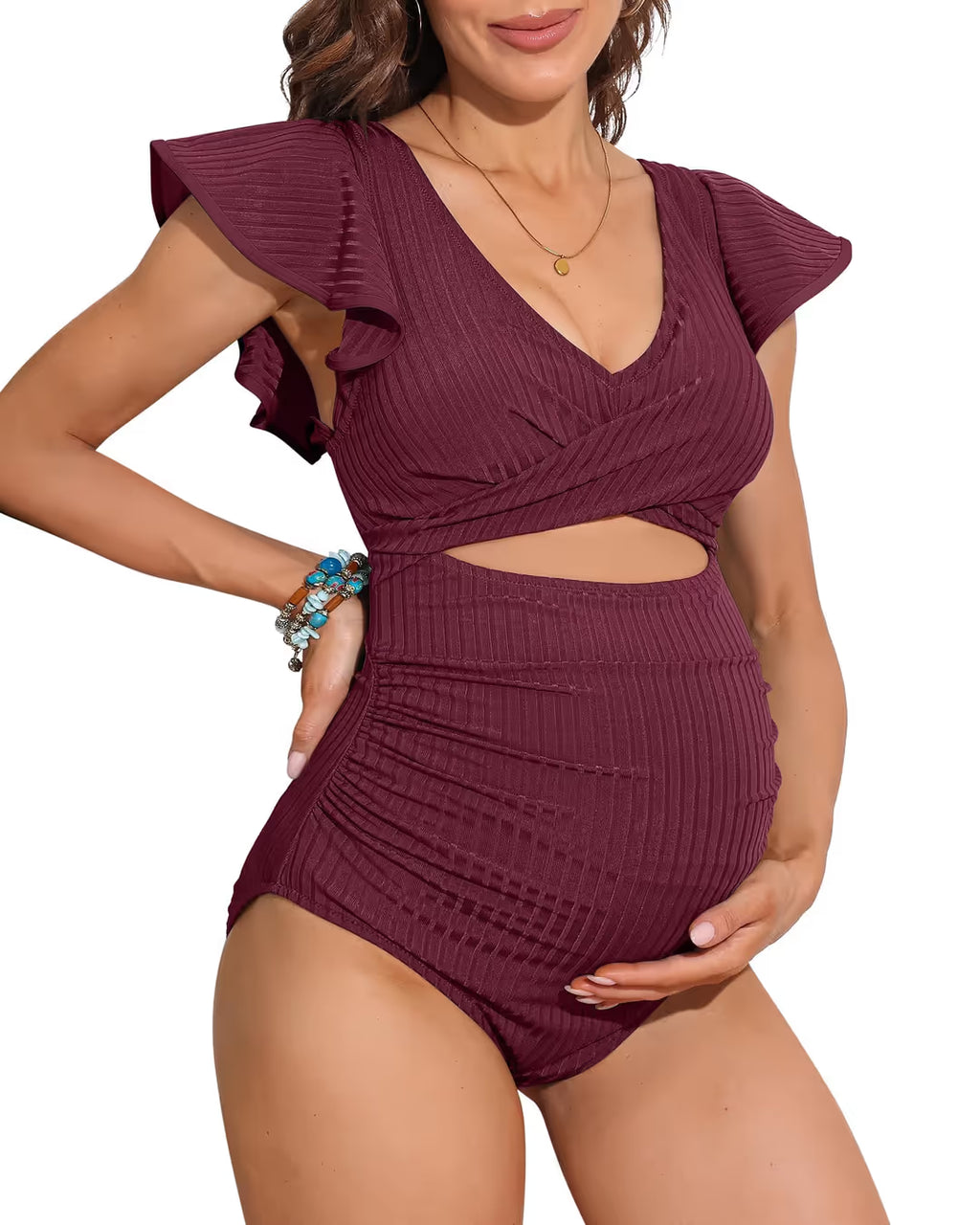 Woman wearing a burgundy ribbed swimsuit with ruffled top on a white background