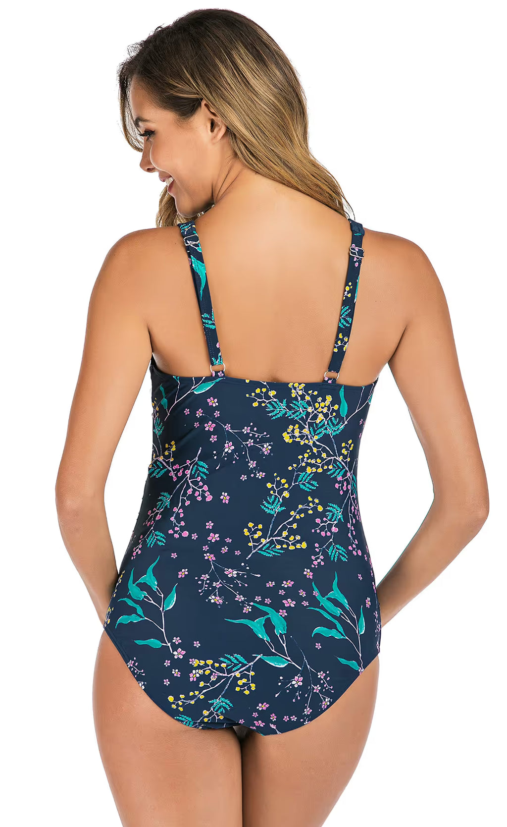 Woman wearing a navy blue maternity swim-suit with floral pattern on a white background