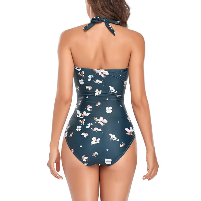 Woman wearing a floral one-piece swim-suit on a white background