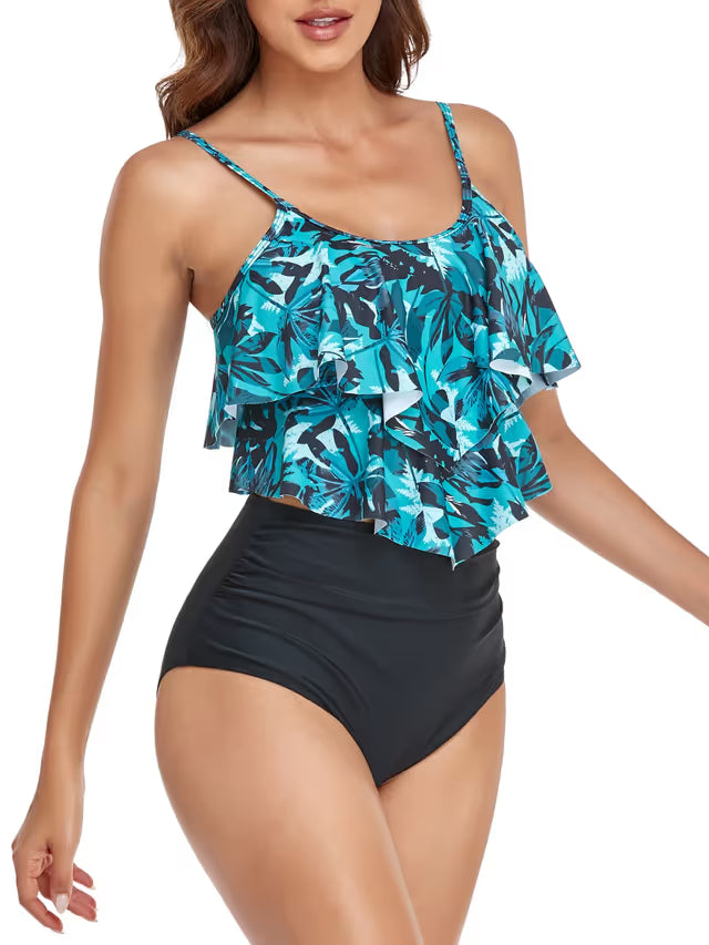 Woman wearing a blue floral top and black high-waisted shorts on a white background