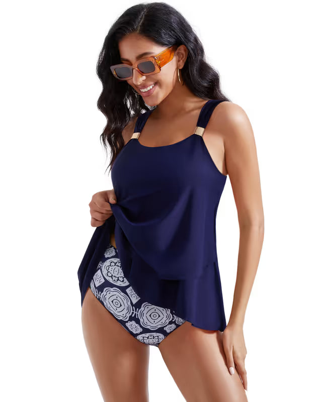 Woman wearing a navy blue tankini with floral patterned bottom on a white background