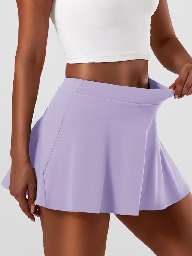 Woman wearing lilac tennis skirt on white background